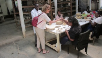 Me shaking hands with woman and store where women hand make jewelry and pottery.