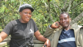 Tour guide and motorbike driver pose on tree stand.